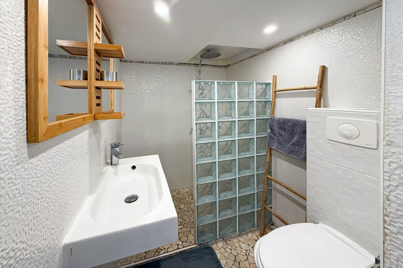 La salle d'eau style bateau et sa douche à l'italienne.